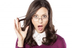 shocked young woman with glasses on a white background