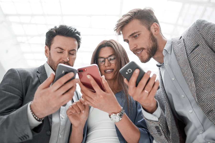 close up.business colleagues reading SMS on their smartphones