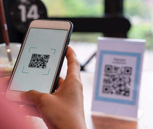 Person Scanning QR Code On Table